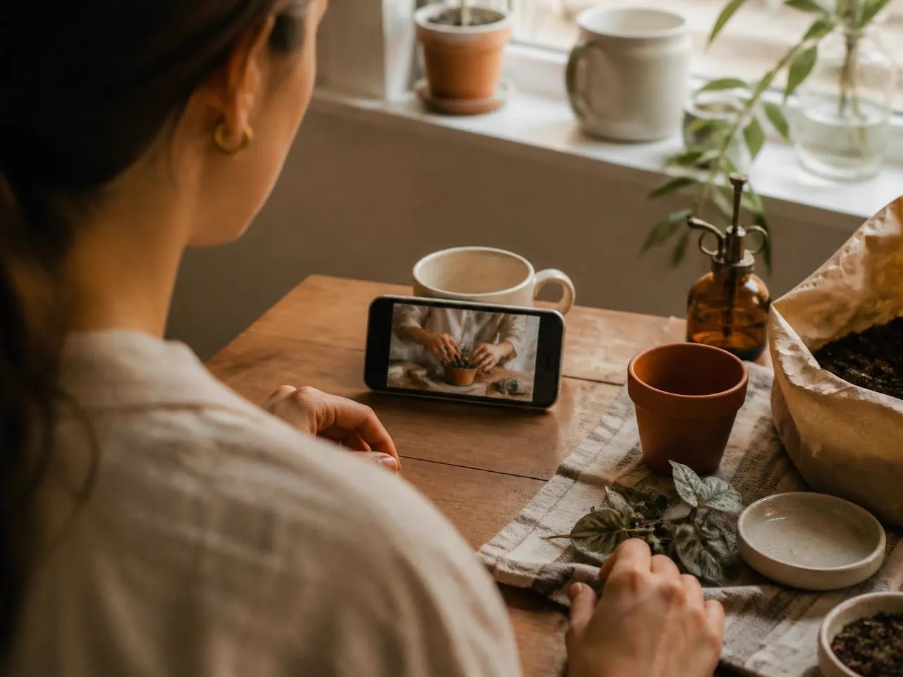 Someone following a short how-to video on a phone while working at a table